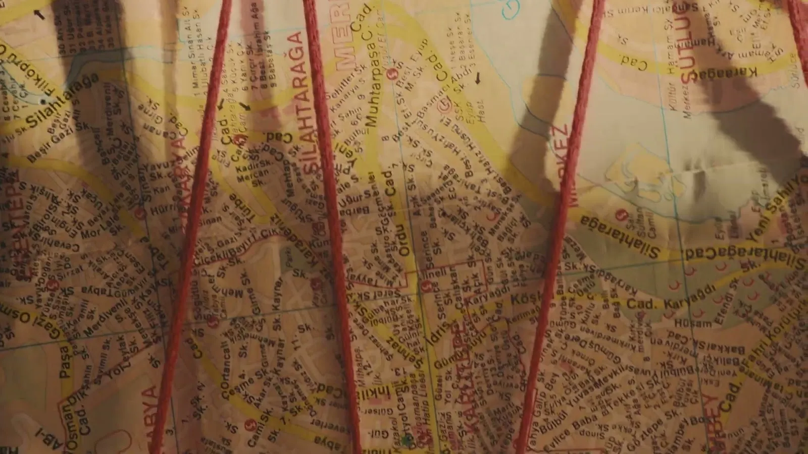 Mapa antigo atravessado por fios vermelhos, imagem do vídeo da cronologia da ERS
